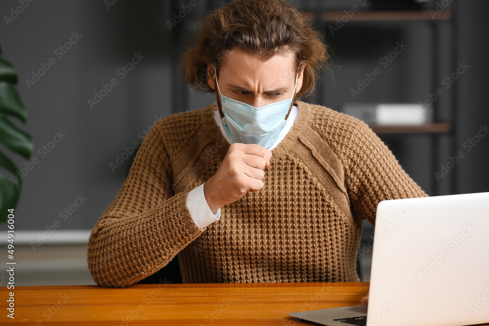 Ill man wearing medical mask in office Ill man wearing medical mask in office