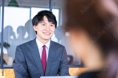 会議で発言をする若いビジネスマン photo