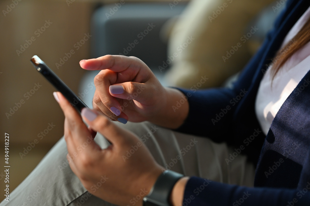 Cropped view hand holding a smartphone and pointing to the screen, for business and technology concept.