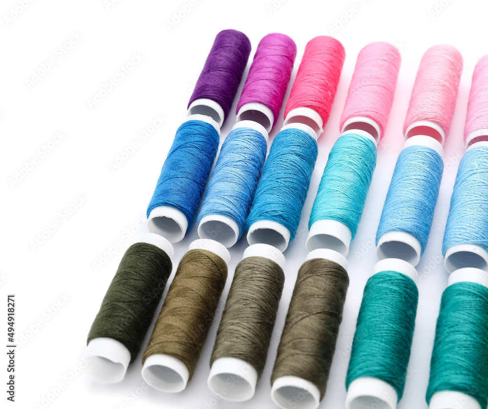 Multicolored sewing thread spools on white background Multicolored sewing thread spools on white background