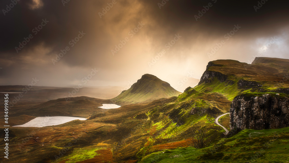 Sunset over Quiraing - famous landmark and tourists attraction on Isle of Skye, Scotland. Majestic landscape scenery with spectacular natural lighting conditions.