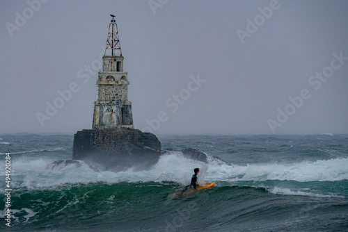 Dramatic view of the lighthouse at Ahtopol, Bulgaria in a wavy sea against a cloudless sky photo