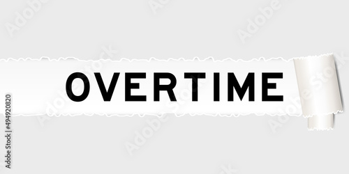 Ripped gray paper background that have word overtime under torn part
