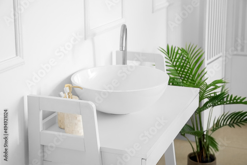 Modern sink near white wall in bathroom