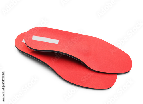 Pair of red orthopedic insoles on white background