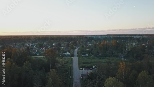 The road to the Russian village in the forest woods on a foggy morning in the light of the rising sun