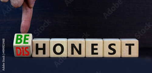 Be honest or dishonest symbol. Turned cube and changed concept words Dishonest to Be honest. Beautiful grey table grey background. Business and be honest or dishonest concept. Copy space. photo
