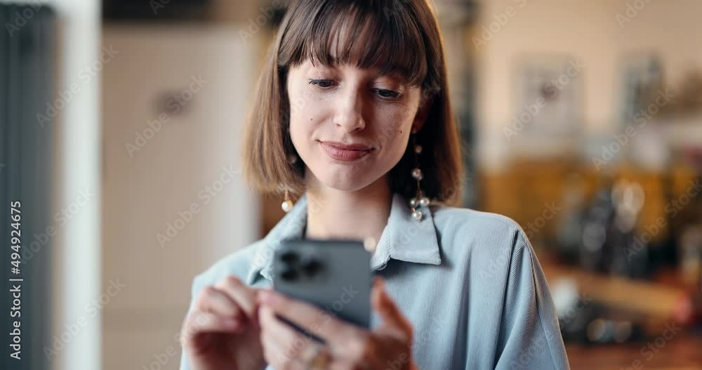 Thoughtful woman using phone at home, close-up view. Caucasian brunette girl surfing internet on smartphone