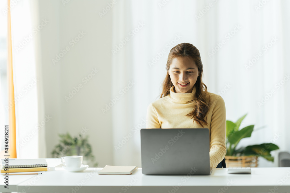 Charming asian businesswoman sitting working on laptop in office. Charming asian businesswoman sitting working on laptop in office.