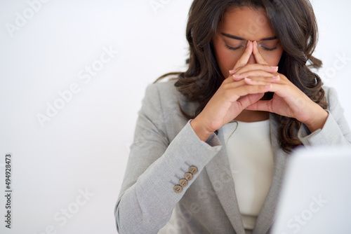 Everyone has a bad day every once in a while. Cropped shot of a young businesswoman looking stressed while working on her laptop. photo