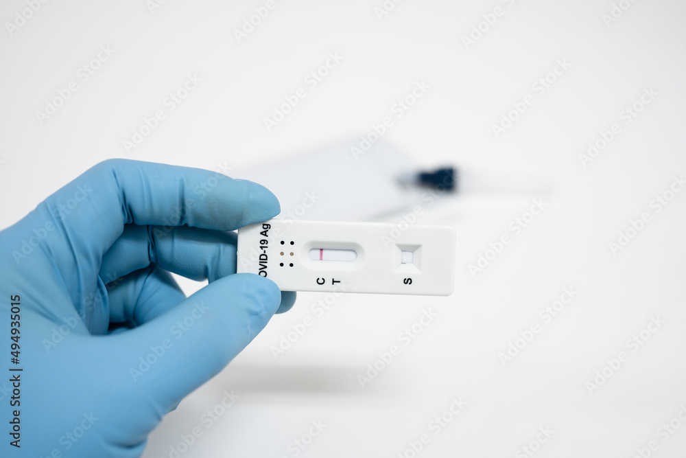 Medical technician wearing blue gloves taking a swab for corona virus sample from potentially infected.Covid-19 laboratory test.Man using rapid antigen test kit for self test . Medical technician wearing blue gloves taking a swab for corona virus sample from potentially infected.Covid-19 laboratory test.Man using rapid antigen test kit for self test .