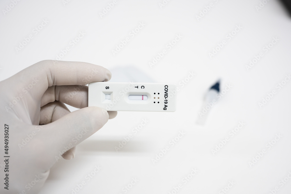 Covid-19 laboratory test.Man using rapid antigen test kit for self test at home.Antigen test kit for self collect nose swab on white background.COVID-19 coronavirus pandemic protection concept Covid-19 laboratory test.Man using rapid antigen test kit for self test at home.Antigen test kit for self collect nose swab on white background.COVID-19 coronavirus pandemic protection concept