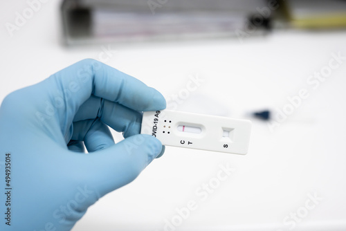 Medical technician wearing blue gloves taking a swab for corona virus sample from potentially infected.Covid-19 laboratory test.Man using rapid antigen test kit for self test .