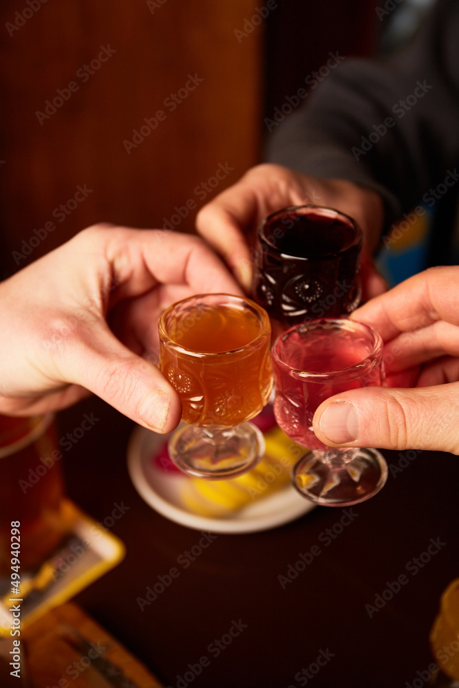 Men and woman drink different liquors in pub. Friends having alcoholic drinks in the bar