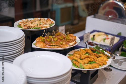 Closeup of delicious plates of food served at a wedding with ceramic plates around them photo