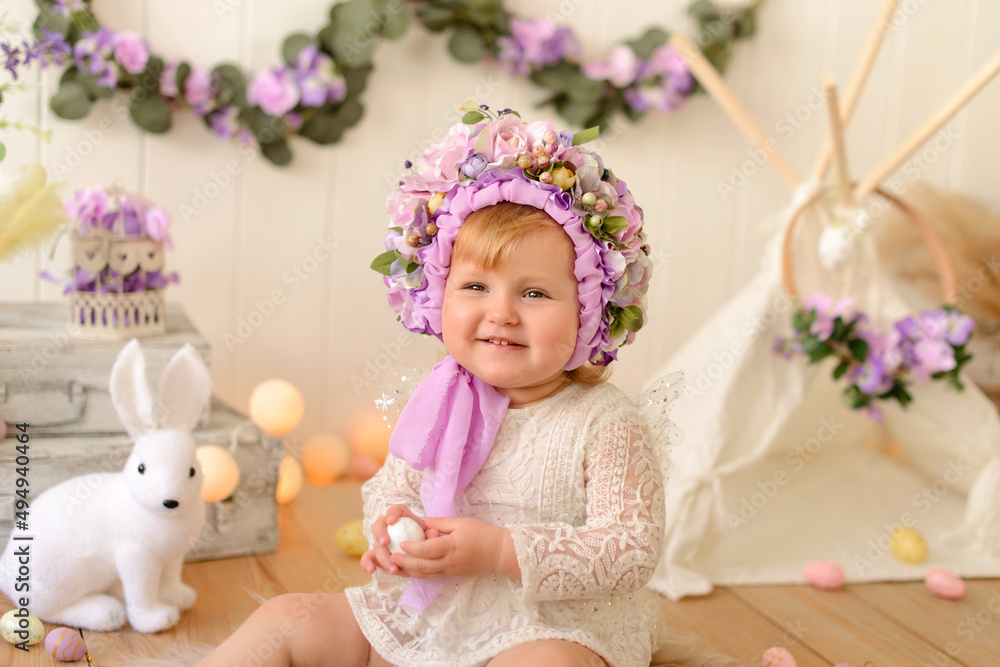 Sweet little girl with decoration on her head and colored Easter eggs on a white wooden background Sweet little girl with decoration on her head and colored Easter eggs on a white wooden background