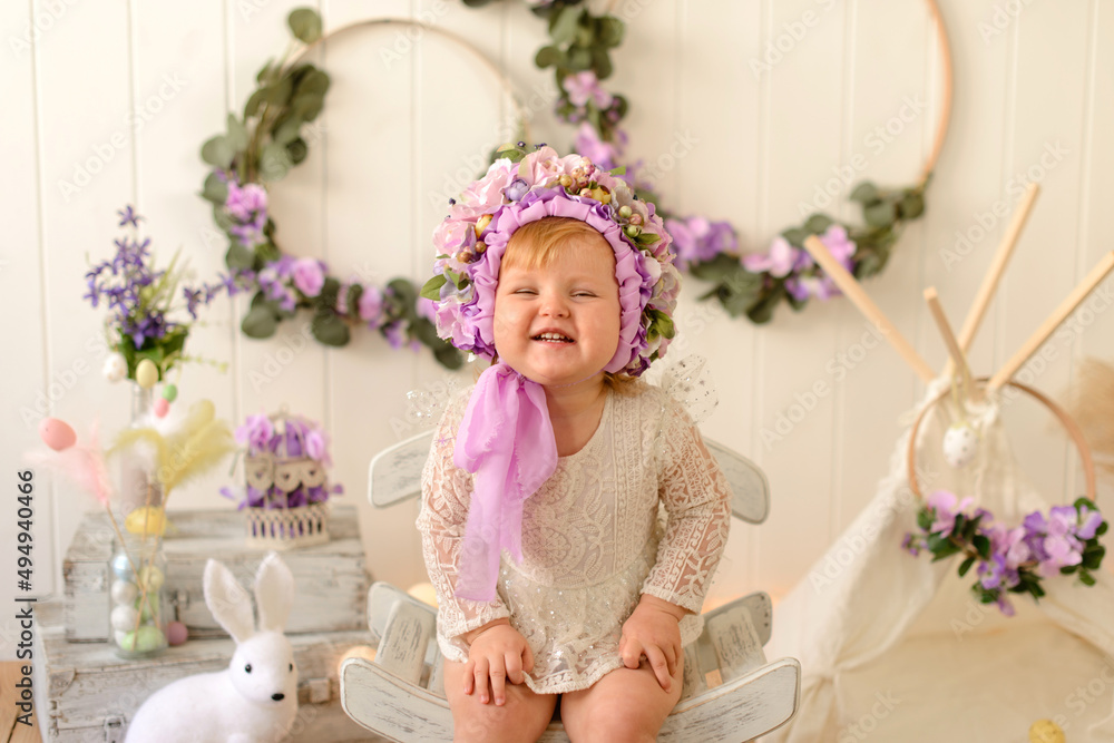 Sweet little girl with decoration on her head and colored Easter eggs on a white wooden background Sweet little girl with decoration on her head and colored Easter eggs on a white wooden background