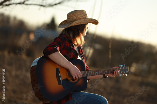 Papier peint cowgirl with guitar at sunset