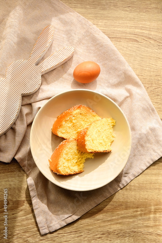 Plate of traditional sweet bread, eaten at Easter time in Croatia. Easter bunny, eggs and flowers on the table. Top view. photo