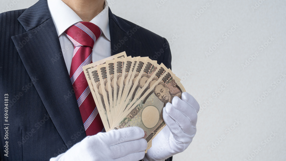 Φωτογραφία 白手袋をはめたスーツ姿の男性。日本円の1万円札を数える│買取り査定イメージ