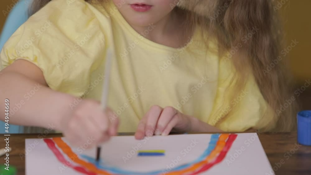 No war. Little girl draws a picture about Ukraine. Draws a rainbow and ...