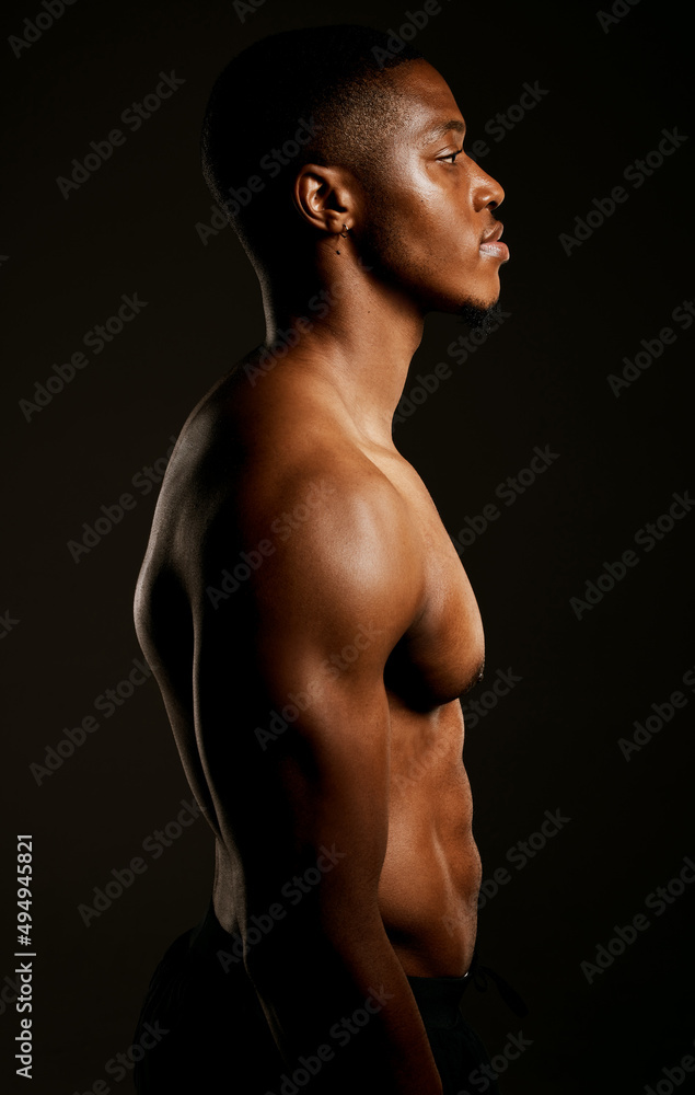 Every pound of muscle is pure man. Studio shot of a fit young man posing against a black background. Every pound of muscle is pure man. Studio shot of a fit young man posing against a black background.