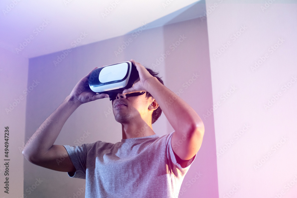 Young man wearing the virtual reality goggles and hand up to touch something Young man wearing the virtual reality goggles and hand up to touch something