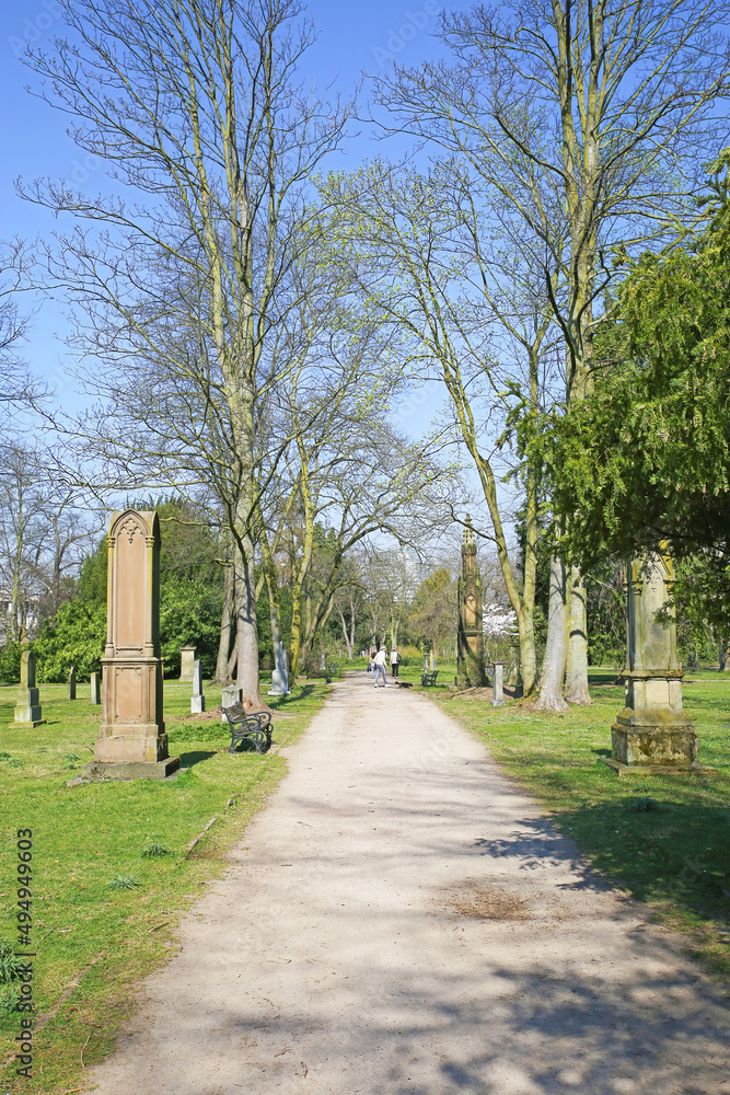 Düsseldorf (Golzheimer Friedhof), Germany - March 21. 2022: View on path through ancient city cemetery with listed monumental tombstones