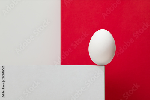 White egg on the white box. White and red background.