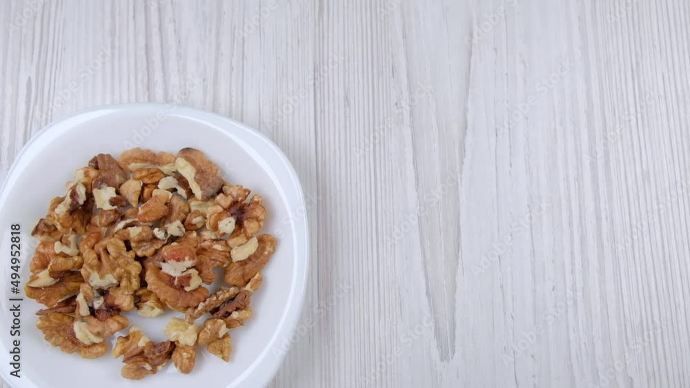Walnuts in a white plate, free space. Plate with nuts on the table, top view. A plate of nuts appears on the table. Healthy food. Healthy food. Healthy food. Man's health Walnuts in a white plate, free space. Plate with nuts on the table, top view. A plate of nuts appears on the table. Healthy food. Healthy food. Healthy food. Man's health