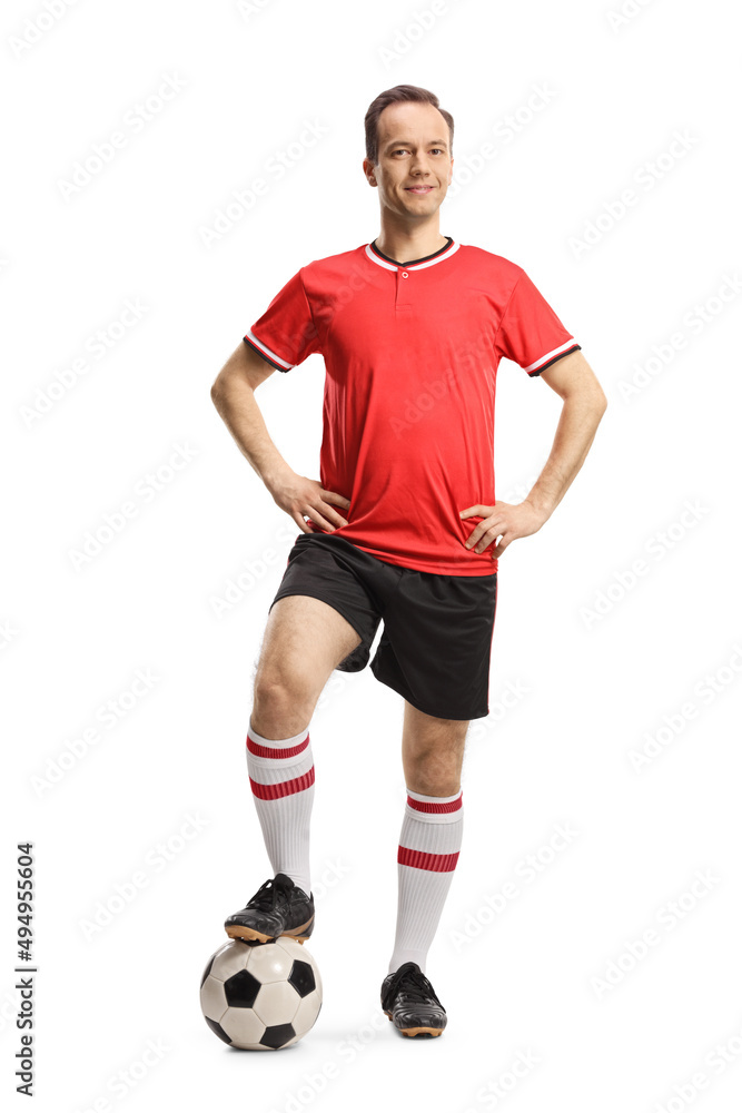 Man wearing football jersey and shorts and posing with a soccer ball