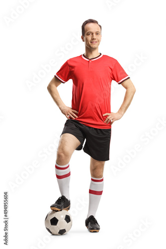 Man wearing football jersey and shorts and posing with a soccer ball