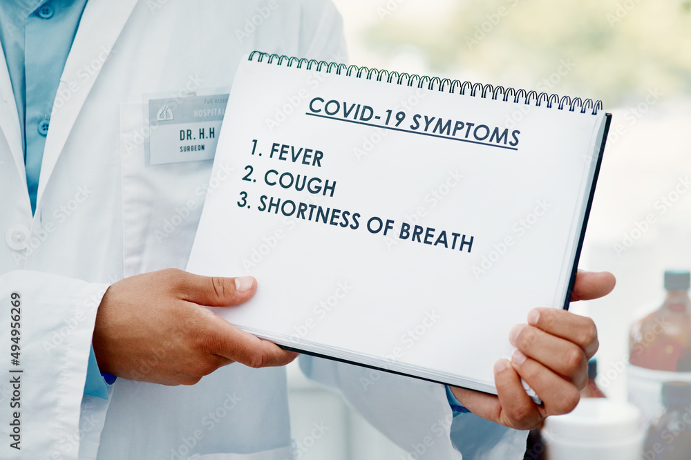 Stay alert, stay safe. Cropped shot of a scientist holding a sign with a list of COVID-19 symptoms on it in a modern laboratory. Stay alert, stay safe. Cropped shot of a scientist holding a sign with a list of COVID-19 symptoms on it in a modern laboratory.