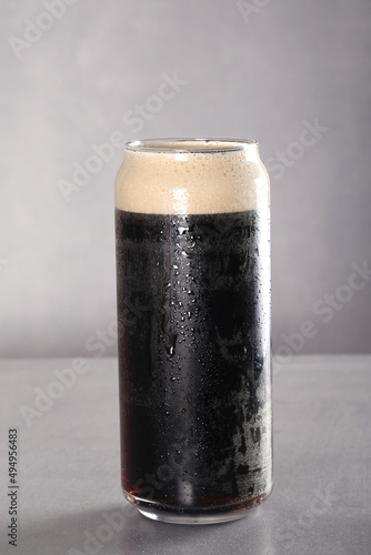 Staut. Dark filtered beer in a glass glass stands on a gray background. Gray background, there is a place to record. photo