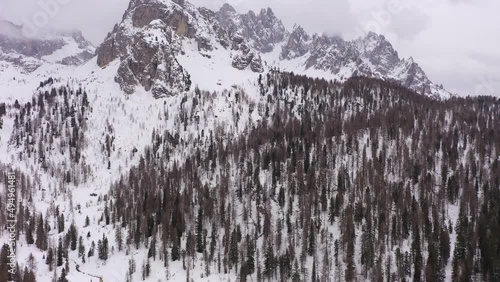 Cadini di Misurina Mountains on Cloudy Winter Day and Forest. Aerial View. Sexten Dolomites, Belluno, Italy. Drone Flies Forward, Tilt Up. Reveal Shot photo