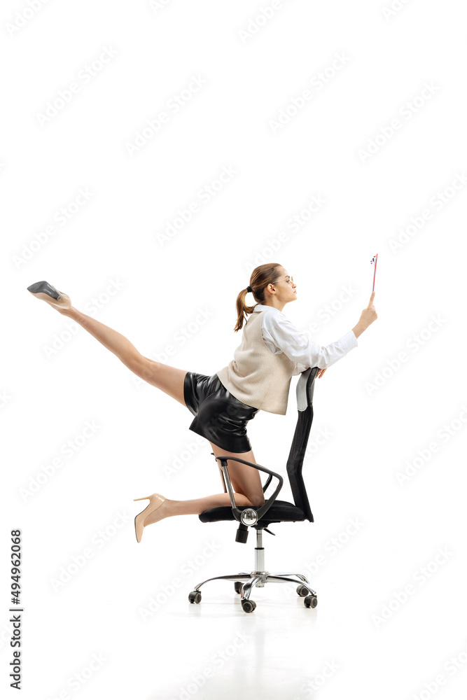 Portrait of young flexible woman in business style clothes with folder making twine isolated over white studio background