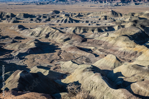 The Badlands of Arizona in late afternoon light and clear blue skies with a slight haze on the horizon.