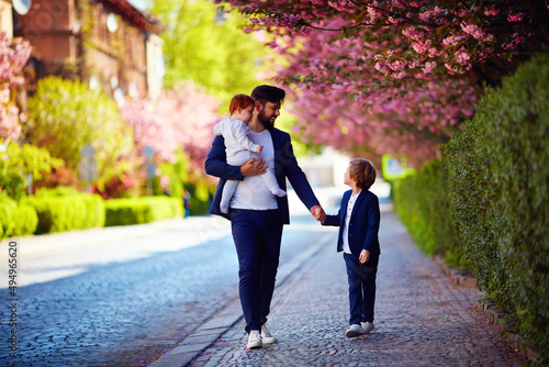 happy father with kids on the walk in spring city, paternal leave