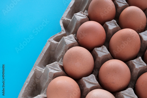 Brown beautiful eggs on a blue wooden background. Farm concept, diet product. Close-up