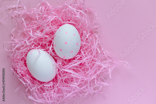 Easter layout. White eggs in a pink nest on a pink background. Bright Easter. Celebration. Postcard. place for text