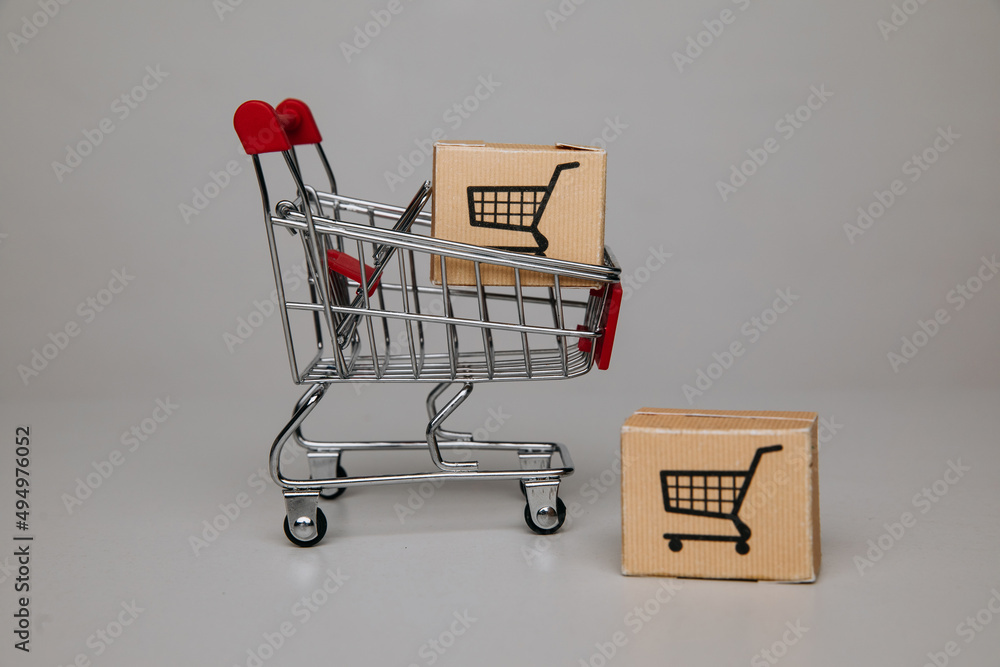 Mini shopping cart with shipping paper boxes. Shopping and delivery concept