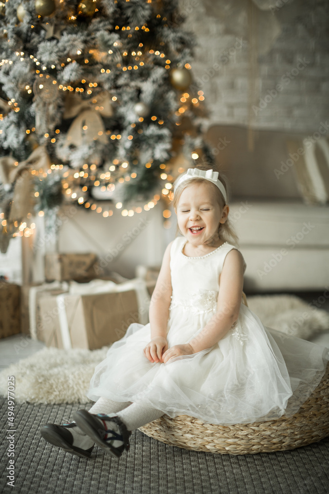 little girl rejoices in the new year. on the background of an elegant Christmas tree