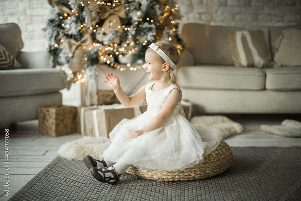 little girl rejoices in the new year. on the background of an elegant Christmas tree