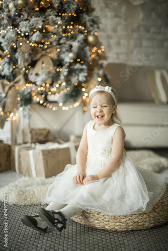 Obraz na płótnie little girl rejoices in the new year. on the background of an elegant Christmas tree w salonie