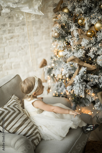 Obraz na płótnie little girl rejoices in the new year. on the background of an elegant Christmas tree w salonie