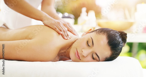 Your back pain will disappear just like magic. Shot of a young woman getting a back massage at a spa.