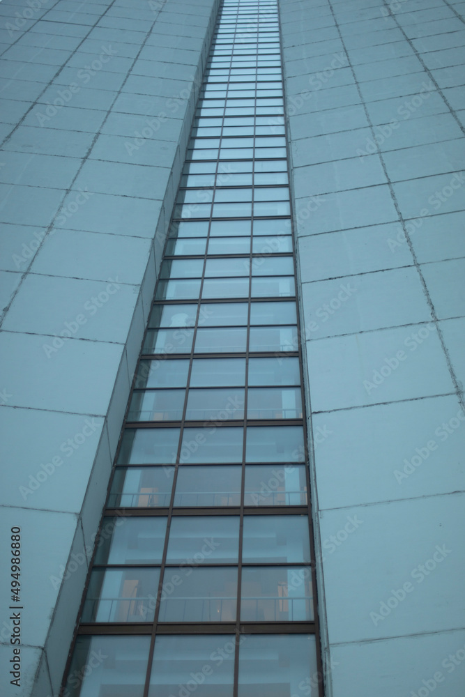 Obraz premium High-rise building on gray day. Architecture details. Surface of wall.
