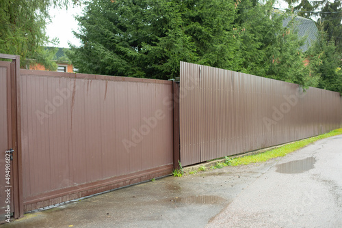 Gates and fence. Sliding gates for entrance to site. Fence around house.