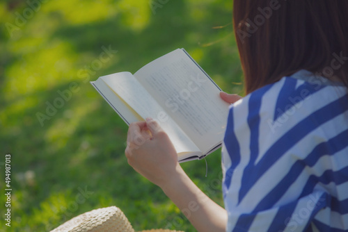 草原で本を読む女性の手元