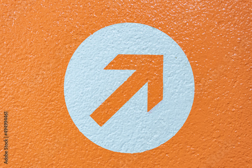 Closeup shot of a painted arrow on the orange background photo